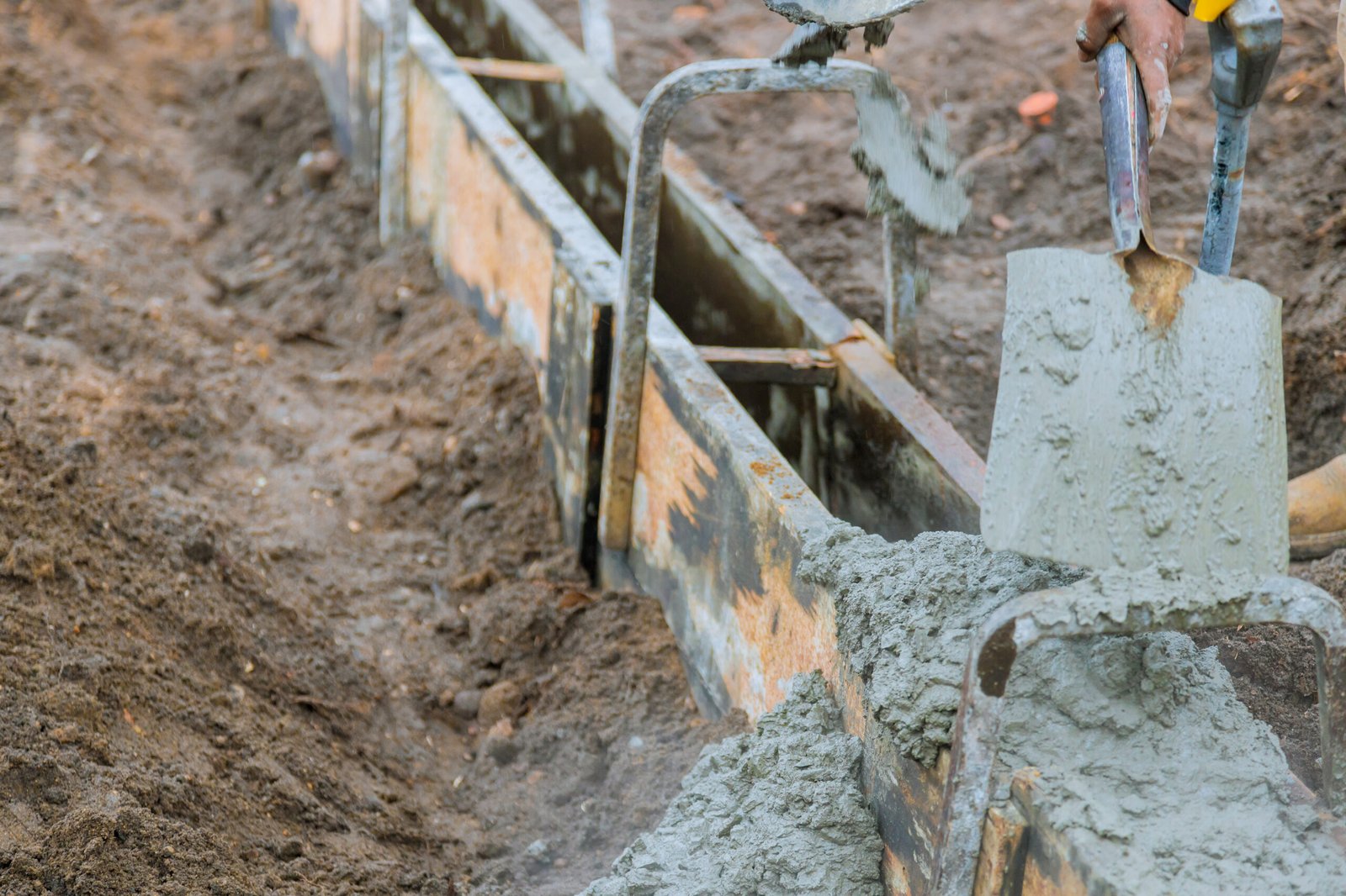 Concrete construction contractor installing a sidewalk, curb on a new urban road street project
