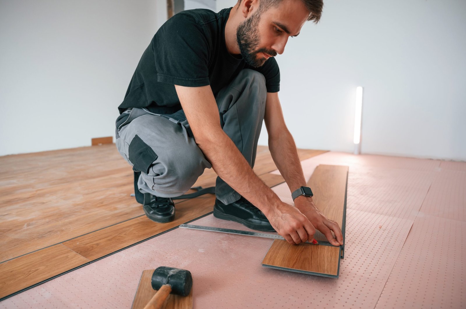Hand work. Man is installing new laminated wooden floor.