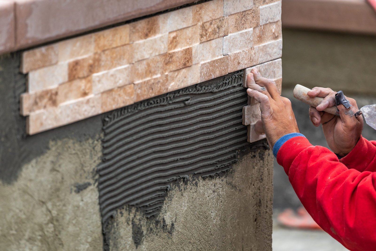Worker Installing Wall Tile at Construction Site.